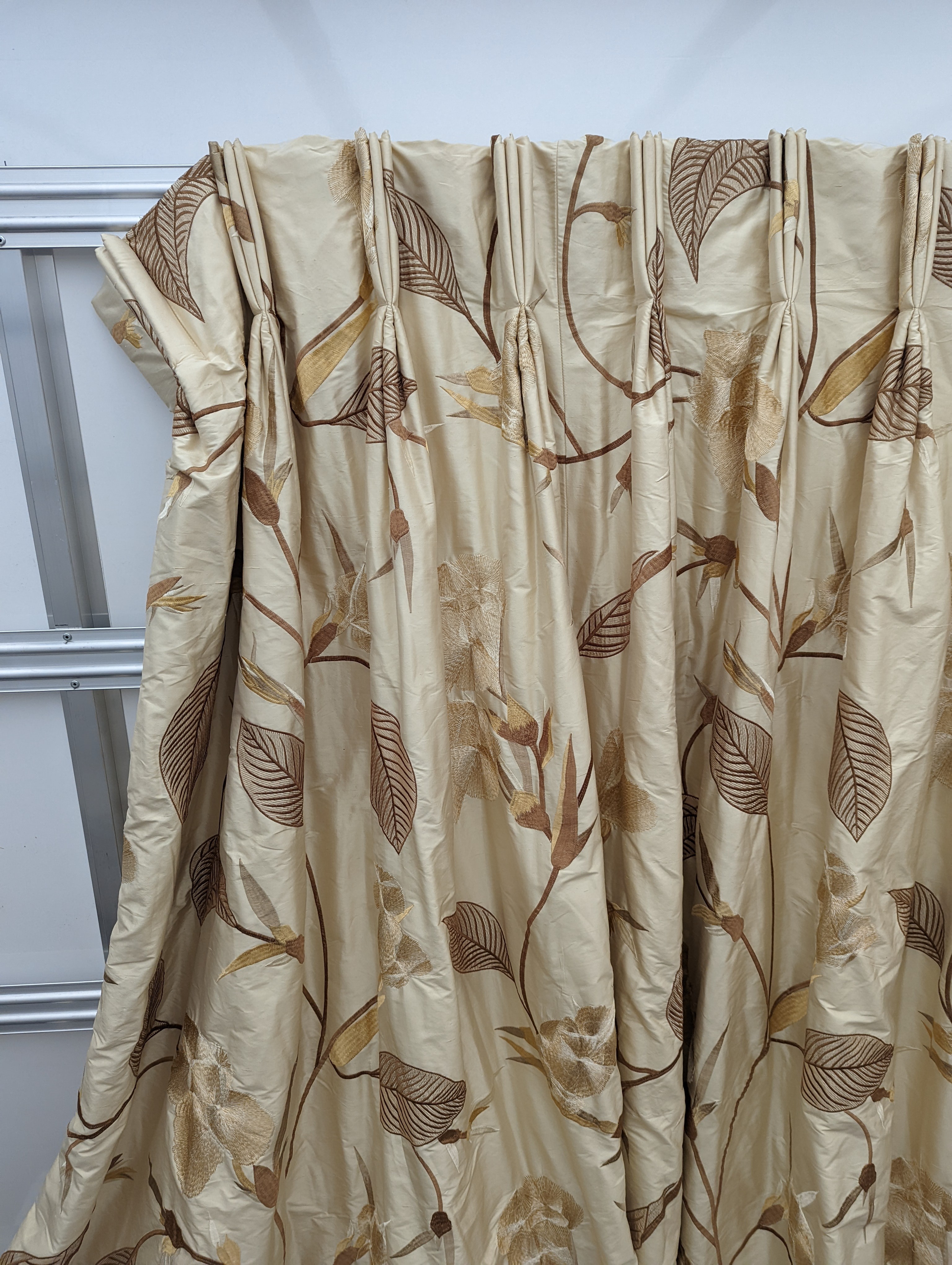 A pair of floral lined curtains. Approximate measurements: Width of top 230cm, Width of bottom 420cm Length 250cm